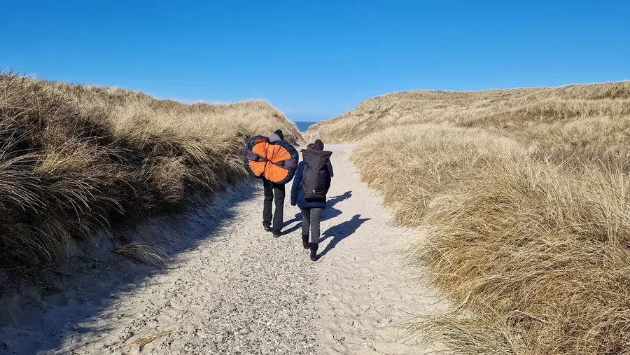 Zwei Teilnehmende auf dem Weg durch die Dünen bei einem früheren Retreat